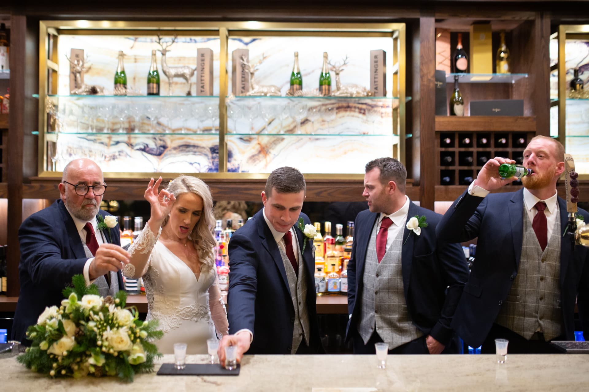 Bride and groomsmen doing shots at the bar